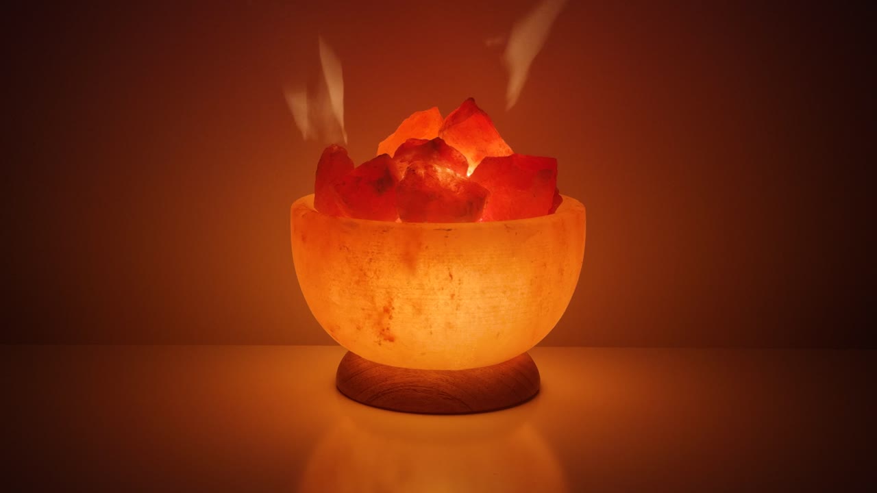 어두운 배경에 대해 테이블에 빛나는 히말라야 소금 램프를 닫습니다