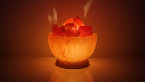 Himalayan-salt-lamp-glowing-on-а-table-against-dark-background,-close-up