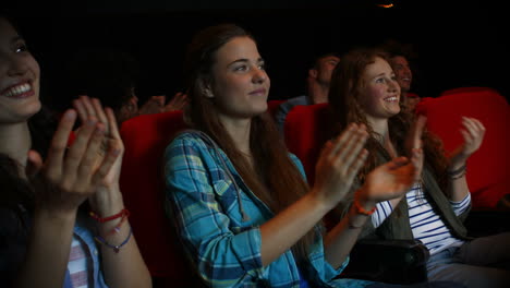 friends watching funny movie in cinema