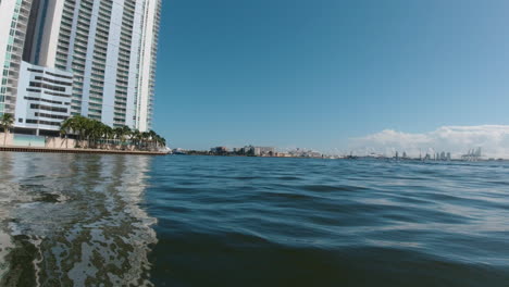 view-from-a-small-boat-approaching-a-tall-building-on-the-calm-waters-of-Biscayne-Bay-near-Miami-Florida