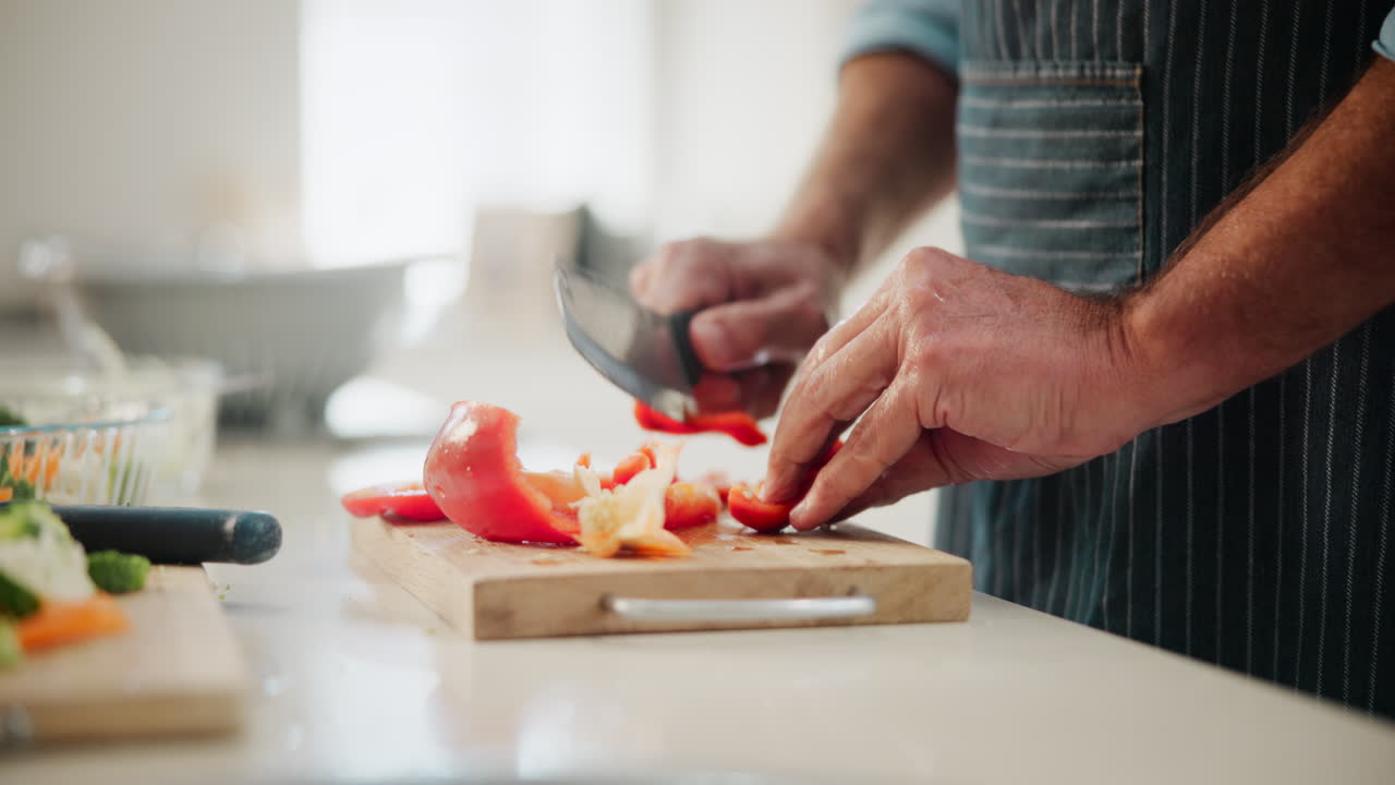 Man chopping red pepper in the kitchen