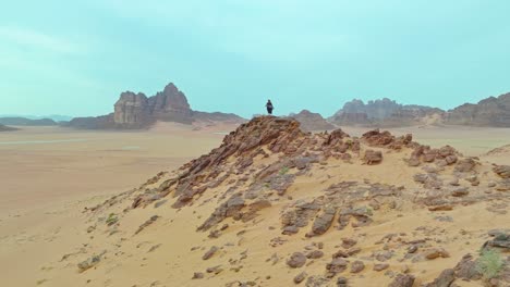 woman in black dress standing on the rock at wadi rum desert in jordan