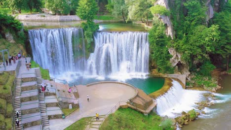 tourists view water flowing down provalije waterfall in spring