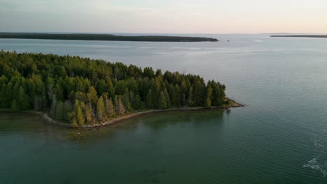 Aerial-descent-and-pan-of-iforested-sland-peninsula-golden-hour,-Lake-Huron,-Michigan,-Les-Cheneaux-Islands