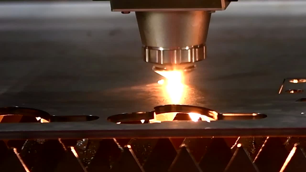 Industrial laser cut machine while cutting the sheet metal with the sparking light.