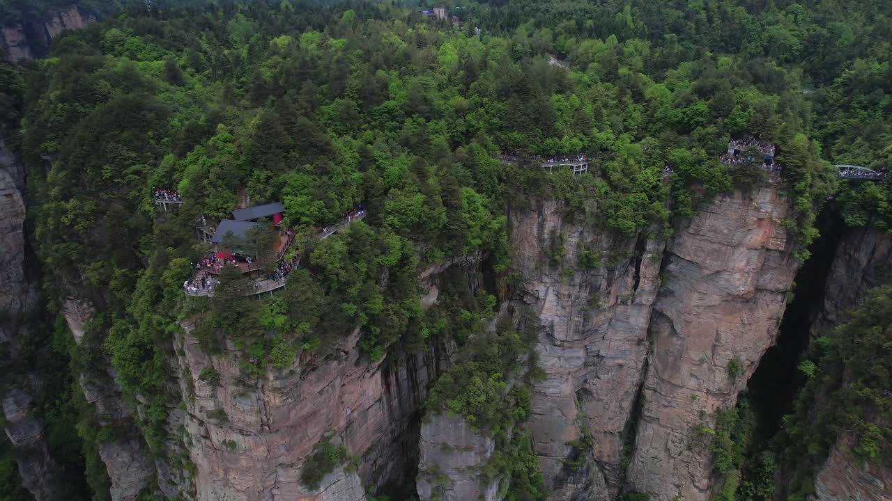 fotografía aérea de turistas explorando las pintorescas pasarelas en lo alto de los exuberantes acantilados en el parque nacional forestal de zhangjiajie, china