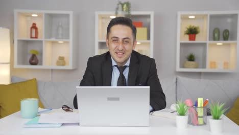 home office worker man smiles at camera.