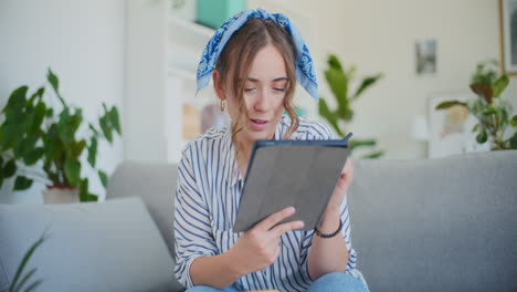 joyful woman shopping online with digital tablet in living room