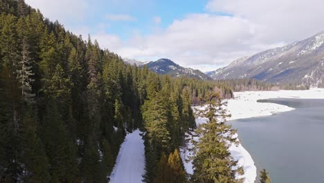 majestic view with drone of lake kachess with evergreen trees and snow in washington state