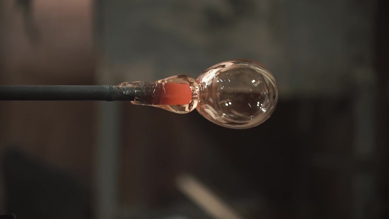 Het smält glasbubbla som formas på en blåspipa.
