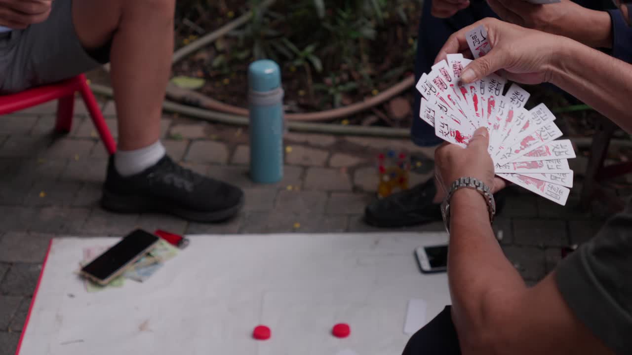 Disponendo carte classiche Tam Cuc su una strada lastricata ad Hanoi, Vietnam