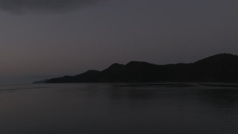 very early morning drone shot of silhouetted and dark islands in the whitsunday islands, qld, australia
