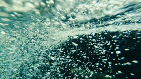 Cámara-Lenta-De-Burbujas-De-Aire-Flotando-Desde-El-Fondo-Del-Río-Hasta-La-Superficie-Del-Agua