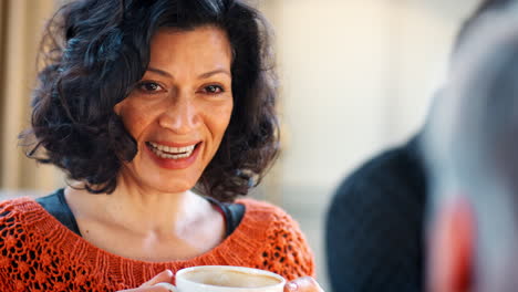 Mujer-De-Mediana-Edad-Reunirse-Con-Amigos-Alrededor-De-Una-Mesa-En-La-Cafetería.