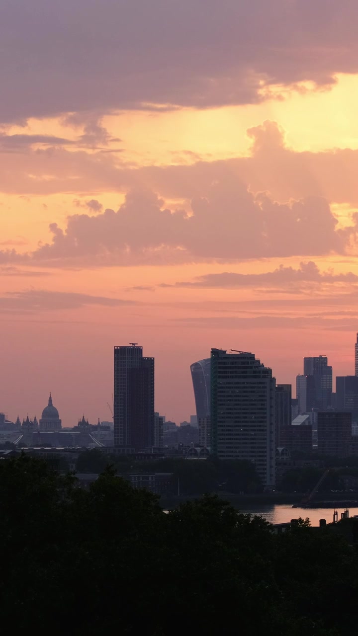 Vista vertical com teleobjetiva da Catedral de São Paulo e do horizonte de Londres na hora dourada, com o Tâmisa refletindo a luz quente do pôr do sol rosa e laranja