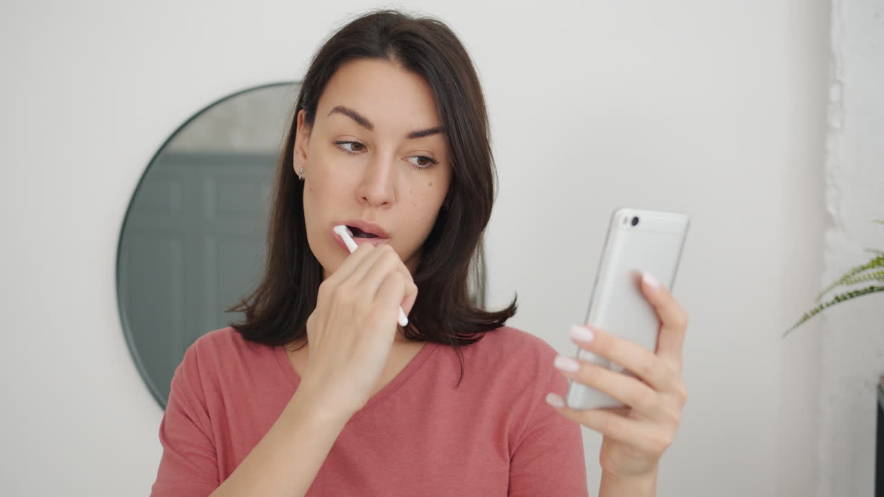 Woman brushing teeth while video-calling