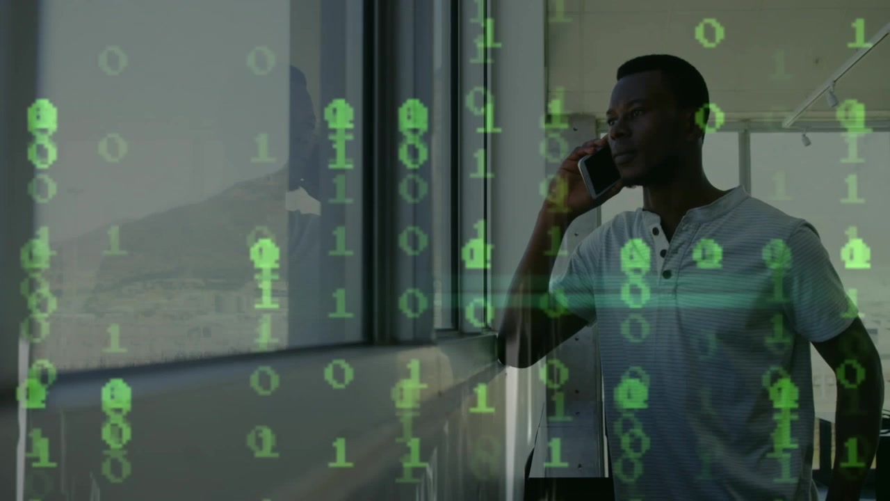 Animation of binary coding over african american man talking on smartphone looking out of window