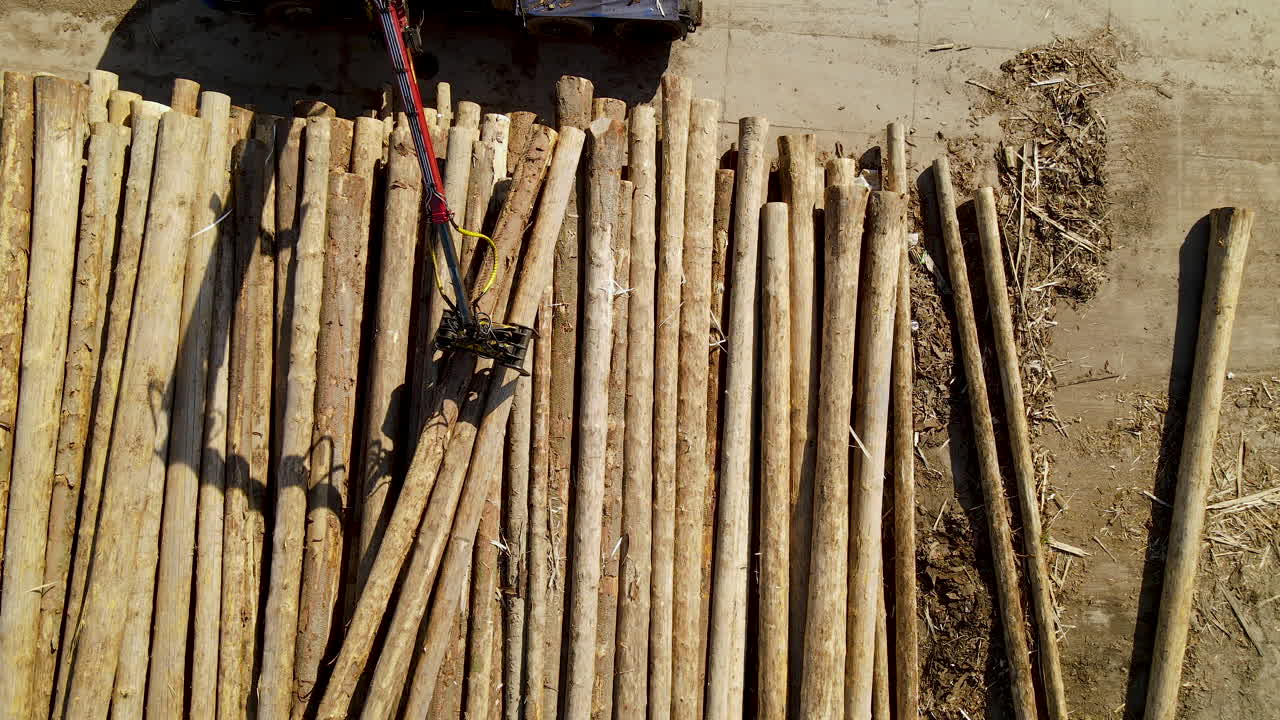 vista aérea de drones de maquinaria maderera que mueve una pila de árboles de madera desde arriba