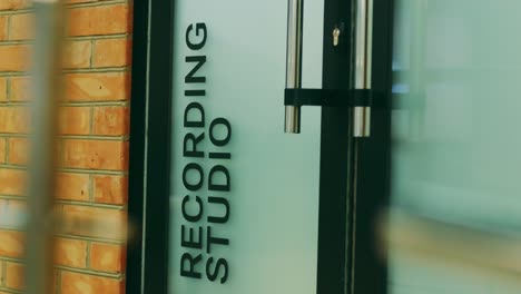 a man in blue jeans enters in the door recording studios