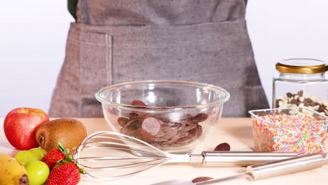 chocolate discs falling into a mixing bowl