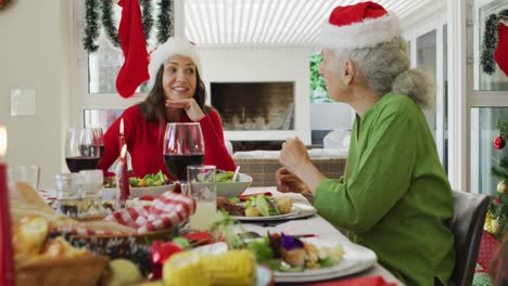 Glückliche-Kaukasische-Erwachsene-Tochter,-Die-Während-Des-Weihnachtsessens-Mit-Der-Mutter-Spricht