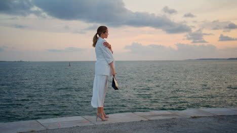 luxurious businesswoman looking sea view standing on embankment calm evening.