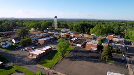 water town aerial with pilot mountain nc in foreground fast flight over town in springtime