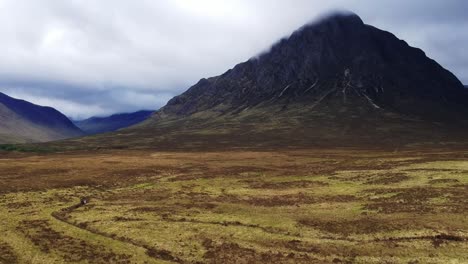 tilt-down drone shot of scottish highland mountain valley landscape