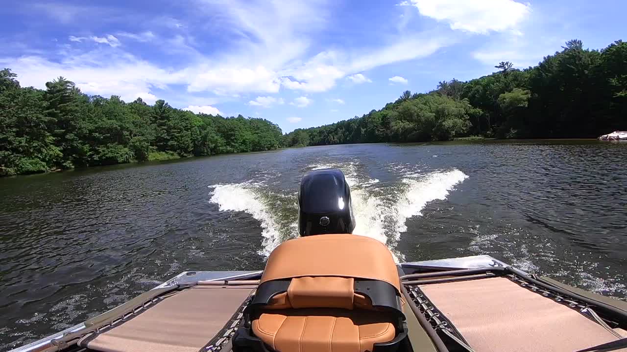 Bass boat cruising on a river.
The motor is clearly visible along with the wake it is creating.