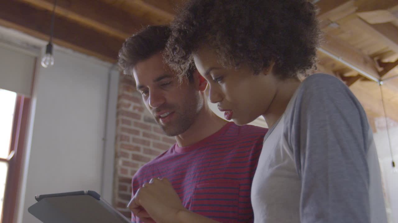 pareja joven usando tableta y hablando, ángulo bajo de cerca, filmado en r3d