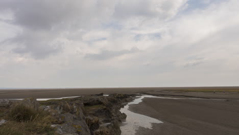 Time-lapse-on-the-coastline-of-England-with-tide-out,-some-people-out-walking