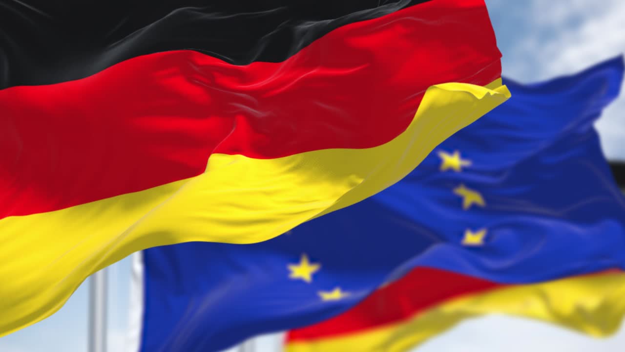 은 날의 배경에 흐릿한 유럽 연합 발과 함께 바람에 흔들리는 독일의 국기 의 완벽한 느린 동작 루프