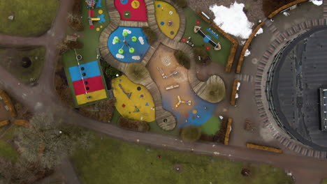 colorful playground in swedish town park on moody winter day, aerial top down view