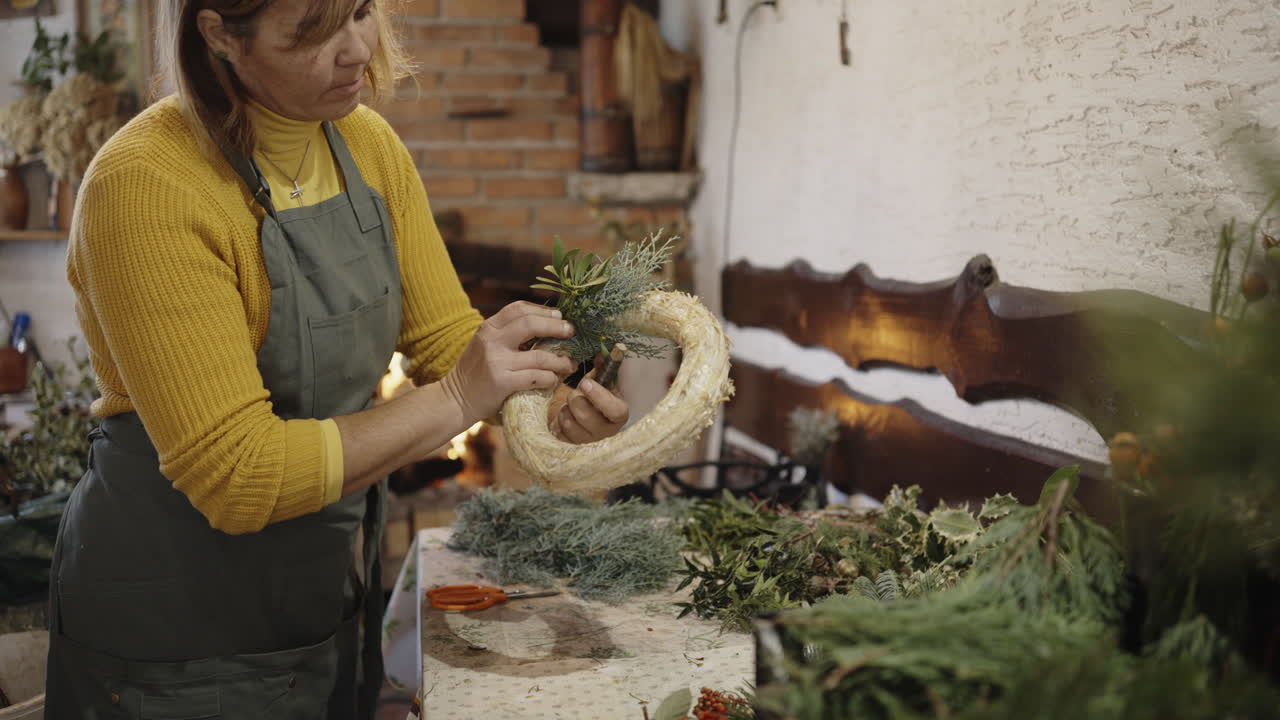 una mujer haciendo una corona de navidad.