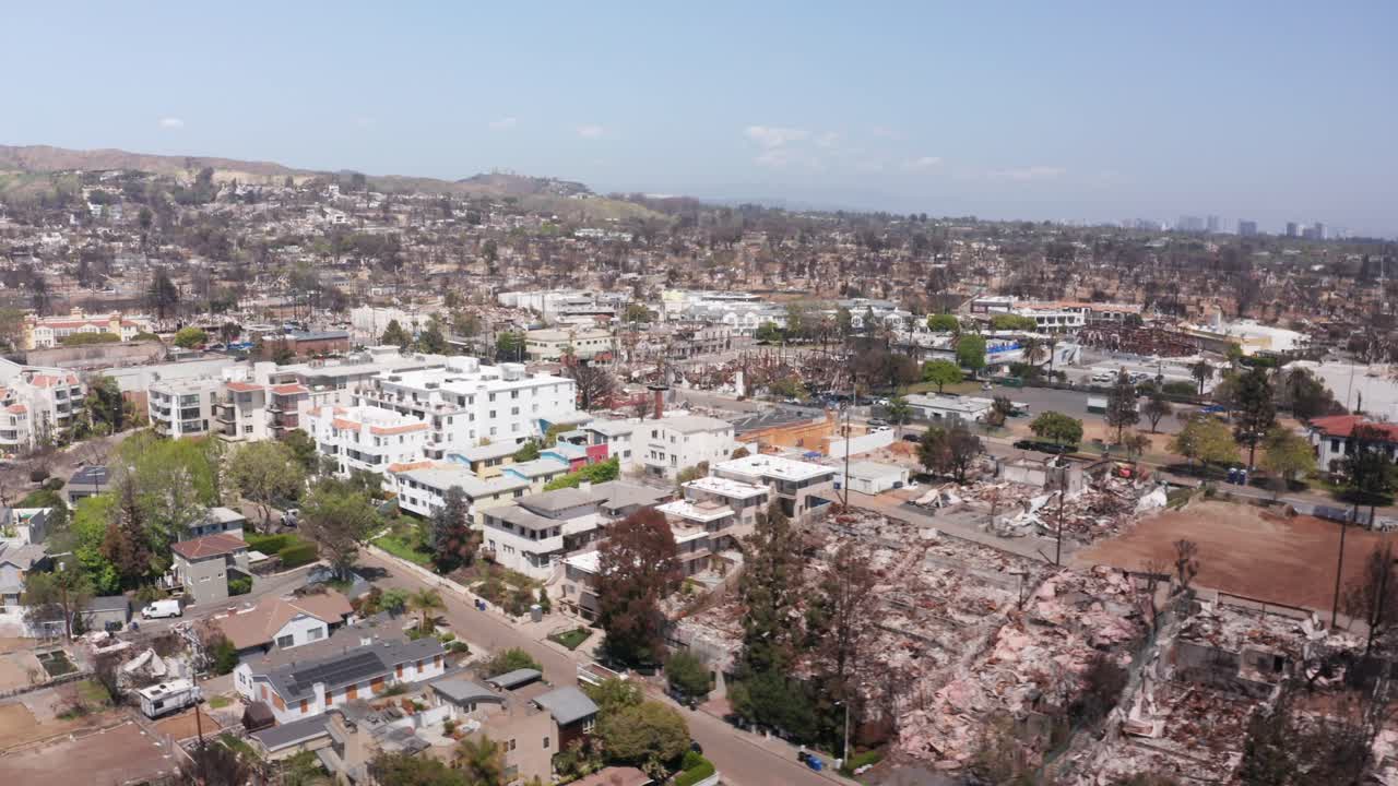 Wide aerial panning shot of Sunset Blvd. in downtown Pacific Palisades after the Palisades Fire in Los Angeles, California. 4K