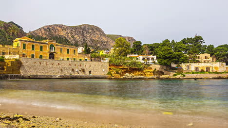 Timelapse,-Pequeña-Bahía-Suave-Con-Vistas-A-La-Pared-De-Piedra,-Edificios-Antiguos-En-Sicilia