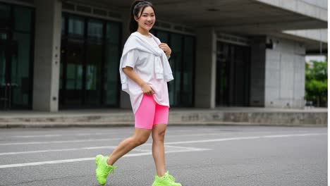 a fit individual embracing an active lifestyle while walking along a modern urban street, showcasing stylish workout attire and a positive attitude