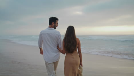 Loving-couple-crossing-seashore-summer-closeup.-Positive-spouses-enjoying-ocean