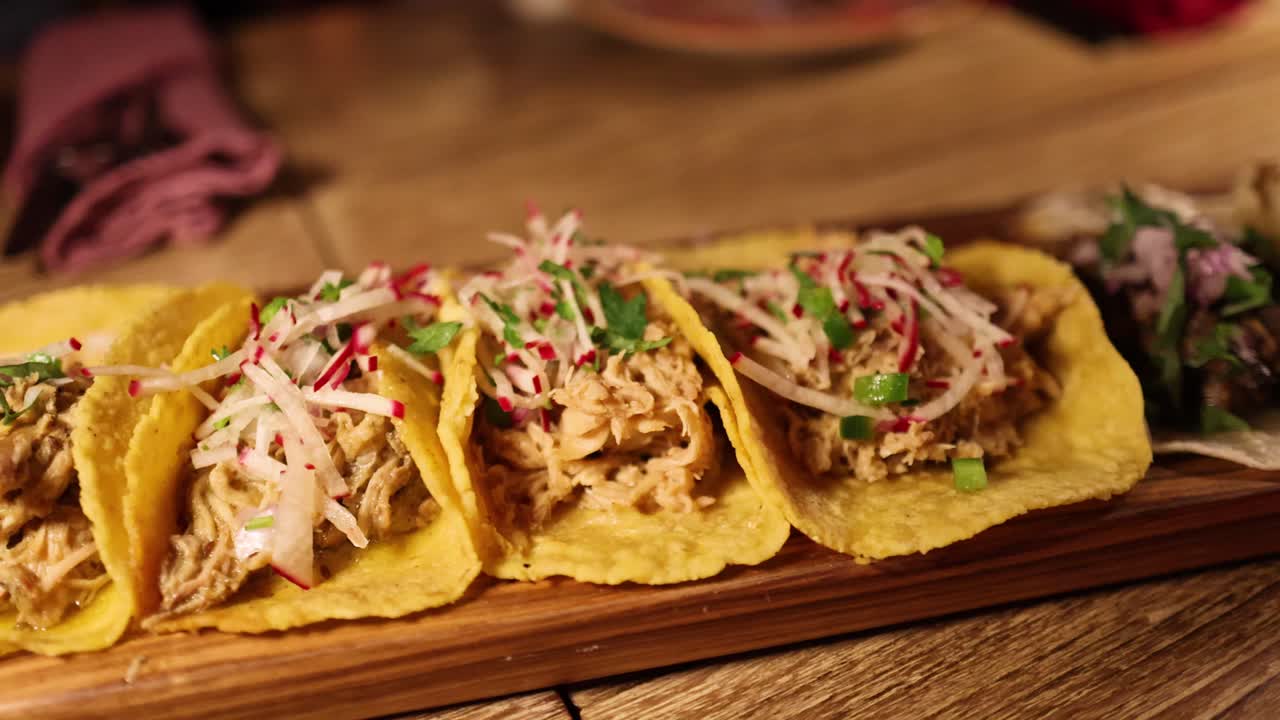 A series of gourmet tacos on a wooden platter in a warmly lit Bangkok restaurant, highlighting vibrant ingredients and culinary presentation