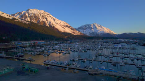 drone reveal and flyover of seward boat harbor and mountains at sunrise in seward alaska