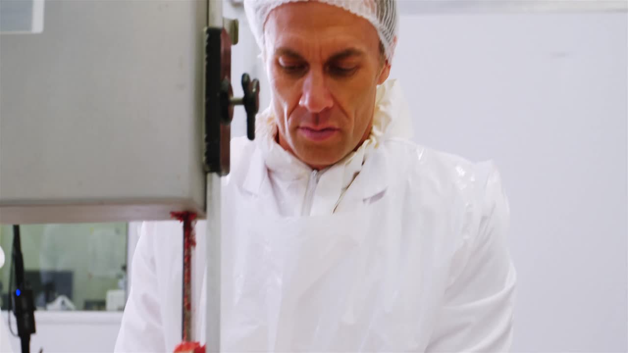 벤드 사 기계 에서 원시 고기 를 잘라내는 도살자