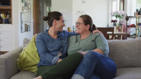 portrait of caucasian lesbian couple looking at camera, embracing