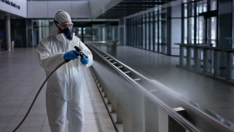 Person in hazmat suit sanitizing a public space