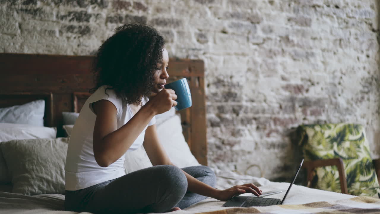 Young Woman Working from Bed