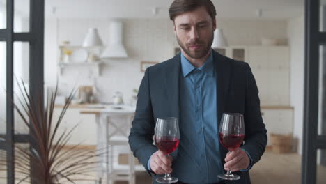 Attractive-family-couple-drinking-red-wine-together-at-home.-Celebrating-success