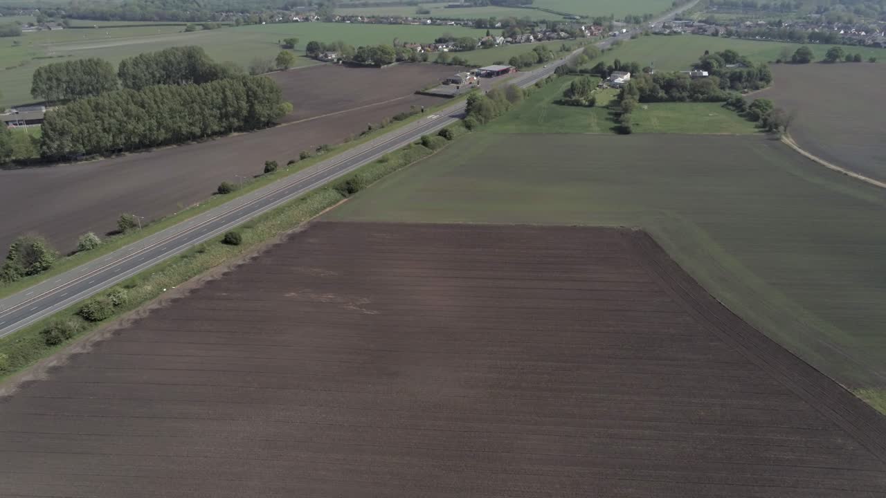 Drone aerial view above British A580 East Lancs highway in rural agricultural countryside
