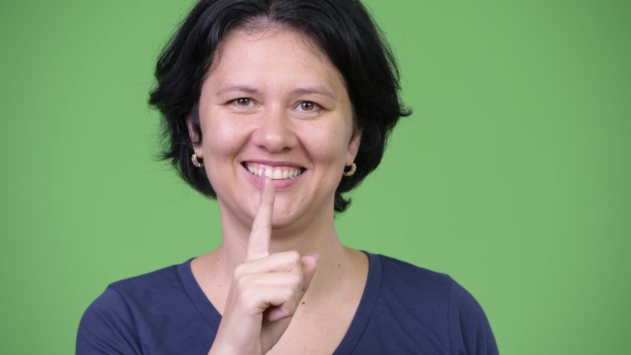 Happy beautiful woman with finger on lips