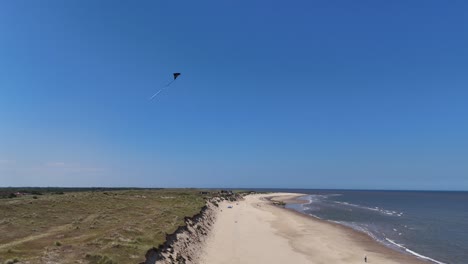 Drohne,-Luftdrachen-Fliegt-über-Der-Küste-Von-North-Norfolk,-Großbritannien,-Blauer-Himmelshintergrund