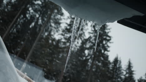 Eiszapfen,-Die-Vom-Dach-Hängen,-Gesehen-Durch-Fensterglas-Aus-Nächster-Nähe