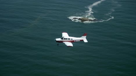 single engine private plane flying over the sea, air to air view